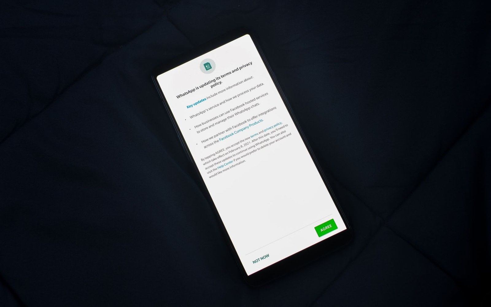 Smartphone screen showing WhatsApp's terms and privacy policy update notice with agree button