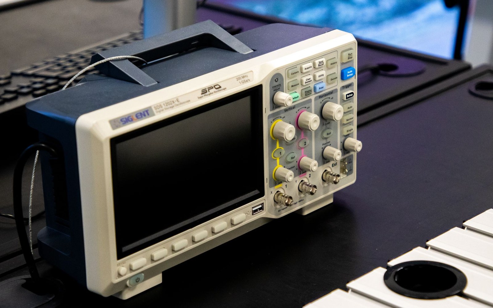 A rack of Android test devices on a laboratory bench, screens lit, photographed from slightly above to show the row of displays